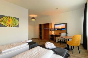 a room with two beds and a table and a dining room at MB Hotel in Bremen