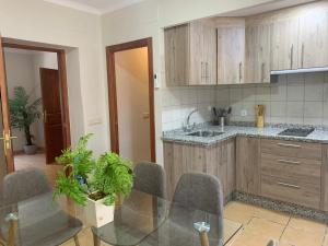 a kitchen with wooden cabinets and a glass table at Casa Rural San Francisco II in Siles