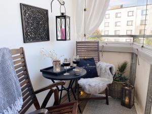 a small table and chairs on a balcony with wine glasses at Apartment Sanctus Nicolaus with sauna in Rovaniemi