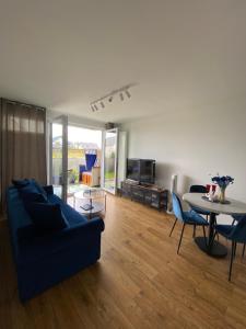 a living room with a blue couch and a table at Apartament Wiczlino in Gdynia