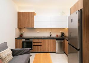 a kitchen with wooden cabinets and a stainless steel refrigerator at ROOF GARDEN SUITE in Matala