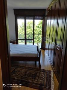 Appartamento Padova zona strategica في بادوفا: غرفة نوم بسرير ونافذة كبيرة