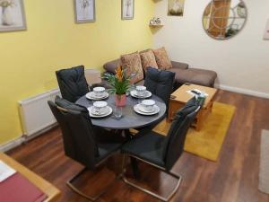 un soggiorno con tavolo, sedie e divano di The musical Ceol Cottage 1-Bedroom - Sleeps four a Ballynahinch