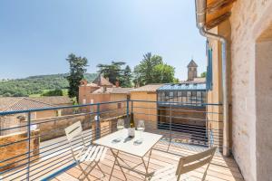 patio con mesa y sillas en el balcón en Chez Romain, en Solutré-Pouilly