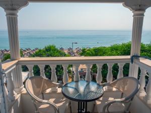 balcón con mesa, sillas y vistas al océano en Vrachos Beach Hotel, en Vrachos