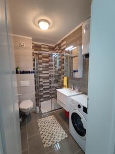 a bathroom with a sink and a washing machine at Passion by Nights & Smiles in Tuzla