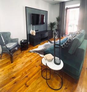 sala de estar con sofá verde y TV en Apartamento de diseño en Malasaña junto a Gran Vía en Madrid