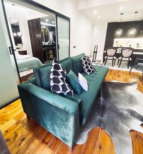 una sala de estar con un sofá verde con almohadas. en Apartamento de diseño en Malasaña junto a Gran Vía en Madrid