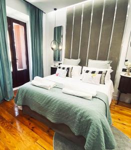 Un dormitorio con una cama grande con almohadas verdes y blancas en Apartamento de diseño en Malasaña junto a Gran Vía en Madrid