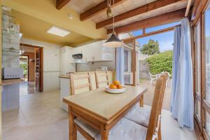 a kitchen and dining room with a wooden table at Villa Passaró in Port de Pollensa