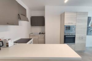 une cuisine avec des comptoirs blancs et un comptoir blanc dans l'établissement Brand new 3 bedroom Apartment close to the sea, à Il-Gżira