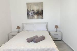a bedroom with a bed with two pillows on it at Brand new 3 bedroom Apartment close to the sea in Il-Gżira