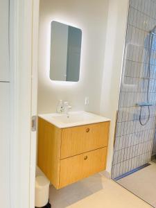 a bathroom with a sink and a mirror at aday - 2 bedroom with modern kitchen and free parking in Aalborg