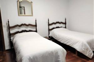 2 camas en una habitación con espejo en la pared en El Chalet de la Poza - Río, barbacoa, Wifi, zona de trabajo, vistas., en Lebena