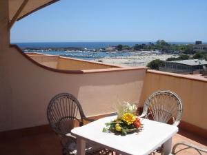 uma mesa branca e cadeiras numa varanda em Hotel La Rusticana em Giardini Naxos