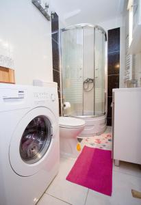 a bathroom with a washing machine and a toilet at Apartments Crvena Orhideja in Split