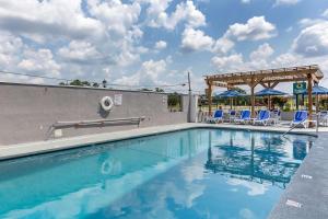 a swimming pool with chairs and a pavilion at Comfort Inn & Suites Spring Lake - Fayetteville Near Fort Liberty in Spring Lake