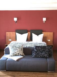 a bedroom with a large bed with red walls at Hotel Garni Demmel & Cie in Rohrsheim