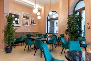 a dining room with tables and chairs and plants at Stadt Hotel Citt&agrave; in Bolzano