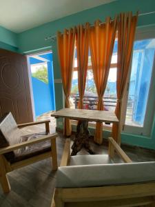 a living room with a table and a couch and a window at JAYANTI MOTHER NATURE HOMESTAY MUNSYARI in Munsyari