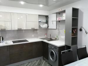 cocina con fregadero y lavadora en Meridian Apartments, en Sochi