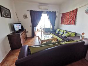 ein Wohnzimmer mit einem Sofa und einem TV in der Unterkunft Appartement Miradorgolf in Cabo Negro