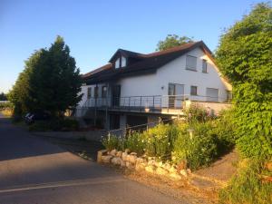 a white house with a landscaping in front of it at Ferienwohnung Blütenweg Kluftern in Friedrichshafen