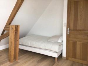 a small bed in a room with a staircase at Ferme de la Haute-Escalles in Escalles