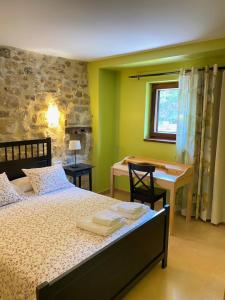 a bedroom with a bed and a desk and a window at Apartamentos Playa Galizano in Galizano