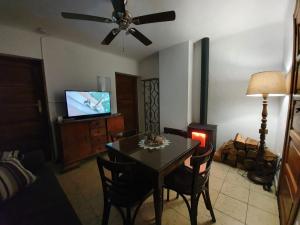 uma sala de estar com uma mesa de jantar e uma televisão em La Estrella de Gredos em Guisando