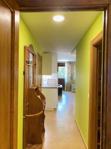 a kitchen with yellow walls and a hallway with a door at Apartamentos Playa Galizano in Galizano
