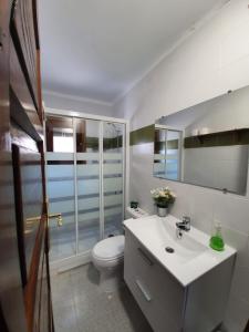 a white bathroom with a toilet and a sink at La Estrella de Gredos in Guisando