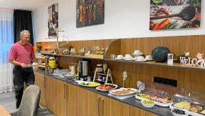 a man holding a plate of food at a buffet at MB Hotel in Bremen