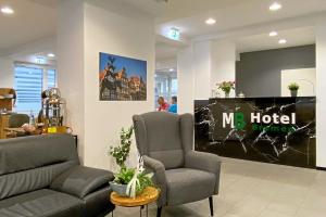 a waiting room with two chairs and a hotel sign at MB Hotel in Bremen