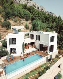 een villa met een zwembad en een huis bij Villa FORTE-Exclusive location with fantastic seaview & infinity pool - up to 8 Pax in Mimice