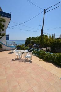 a patio with a table and two chairs and the ocean at Marianthi Studios Stegna in Archangelos
