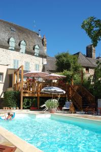 una mujer y un perro sentados en una piscina en Auberge Saint Fleuret, en Estaing