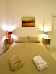 a bedroom with a bed with two towels on it at Casa Argento in Sciacca