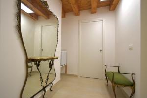 um espelho num quarto com uma cadeira e uma porta em Casa Argento em Sciacca