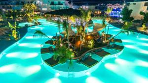 an aerial view of a resort pool at night at Letsos Hotel in Alykes