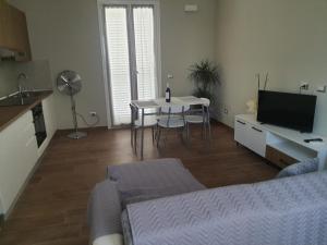 a living room with a bed and a table and a television at Alloggi di porta po in Cremona