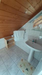 a bathroom with a sink and a toilet and a mirror at Pátri Apartmanház in Keszthely