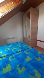 una camera con letto blu, lenzuola blu e armadio di Pátri Apartmanház a Keszthely