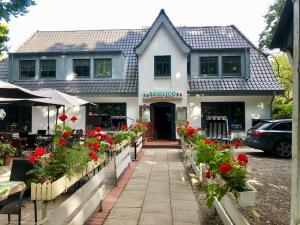 a building with red flowers in front of it at Ferienwohnung „Die Koje“ Hohwacht/Ostsee in Hohwacht