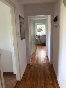 a hallway with a wooden floor and a window at Ferienwohnung „Die Koje“ Hohwacht/Ostsee in Hohwacht