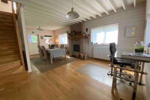 a living room with a table and a fireplace at Charming house in the woods with private wellness in Schilde