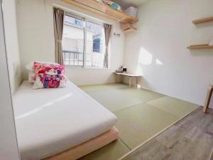 een witte kamer met een bed en een raam bij YUYU-Wa-3 --Self Check-in -- Room Number & Password is in the following email in Tokyo