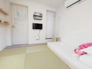 Habitación con cama y TV en la pared. en YUYU-Wa-3 --Self Check-in -- Room Number & Password is in the following email en Tokio