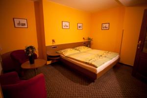 a bedroom with a bed and a table and a chair at Hotel U Jiřího in Humpolec