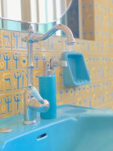 a bathroom sink with a faucet and a blue soap at Happy Place! Big, Bright & Central - Ideal for families and groups of friends in Patra